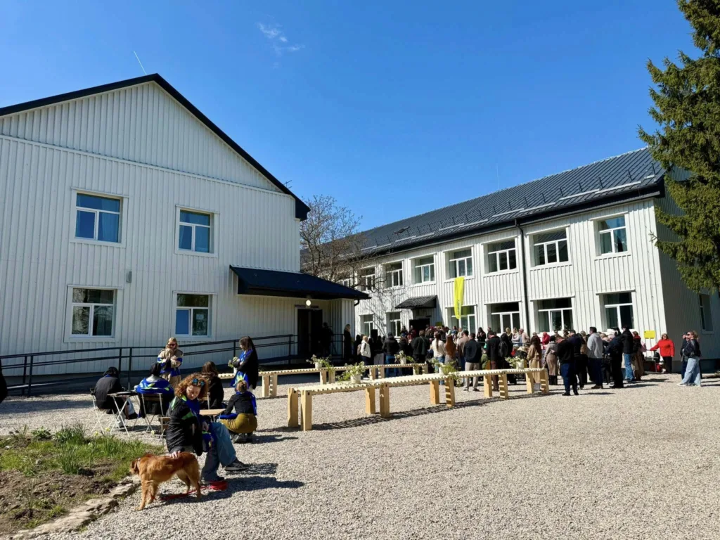 Люди біля білої будівлі на сонячній площі