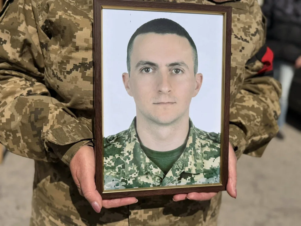 Військовий тримає фото солдата у рамці