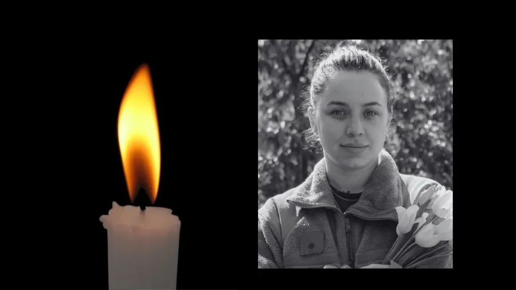 Свічка пам’яті та портрет жінки з квітами