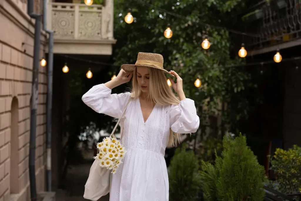 Жінка у білій сукні з ромашками на вулиці