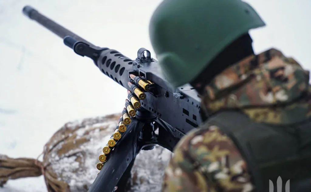 Військовий стріляє з кулемета взимку