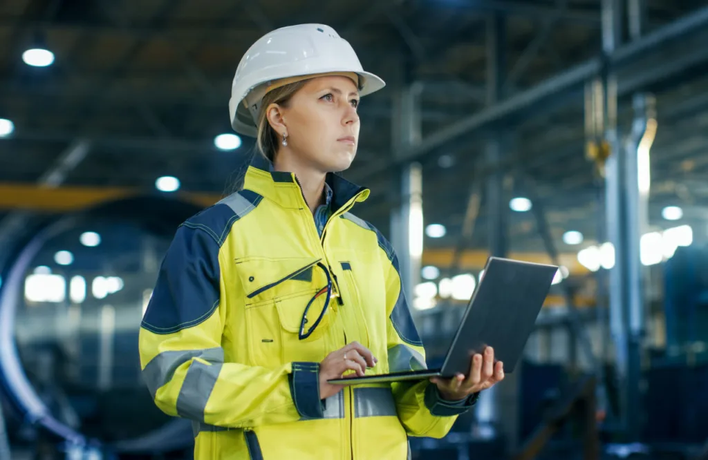 Інженер на заводі працює з ноутбуком