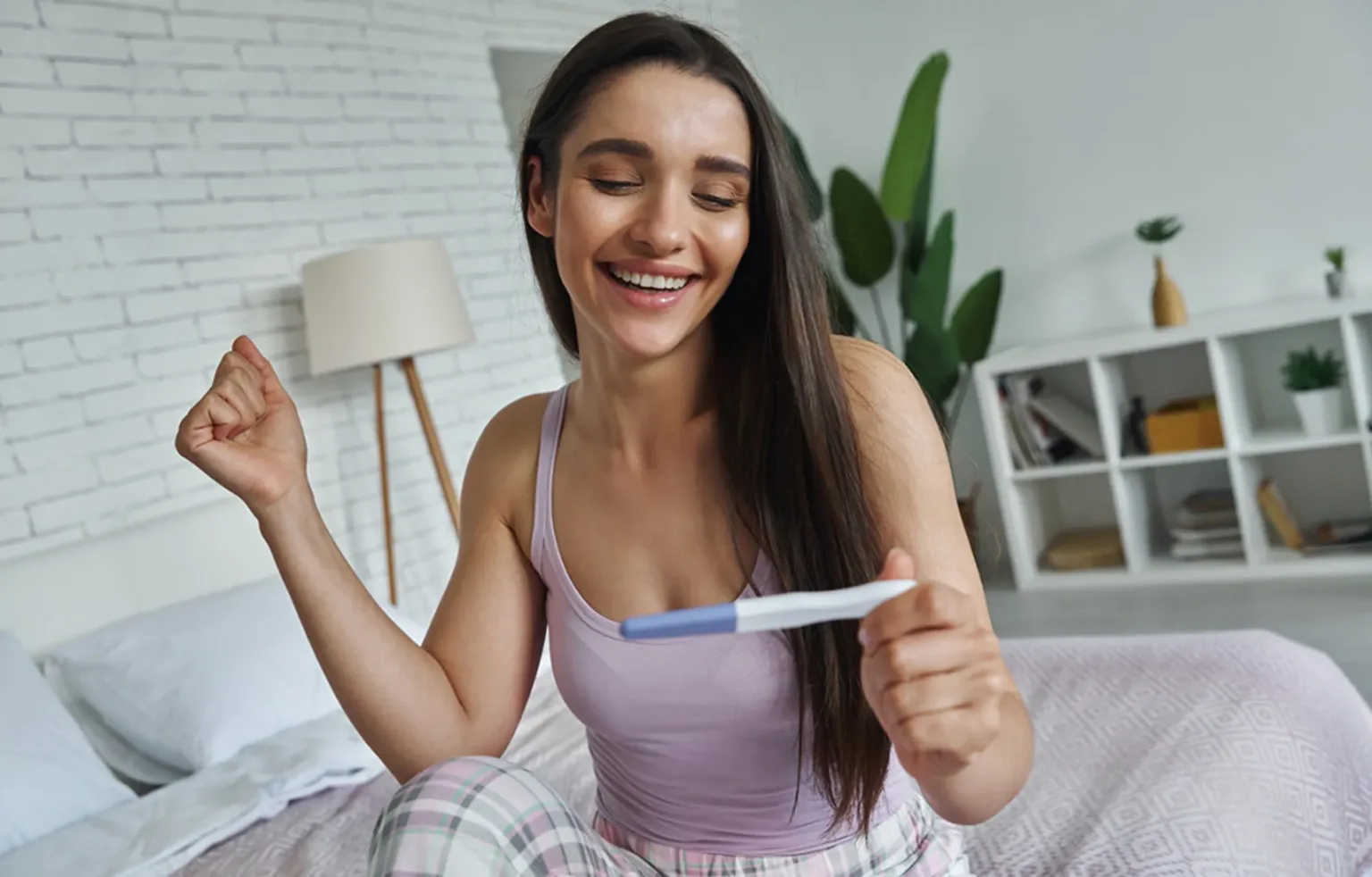 Жінка радіє позитивному тесту на вагітність