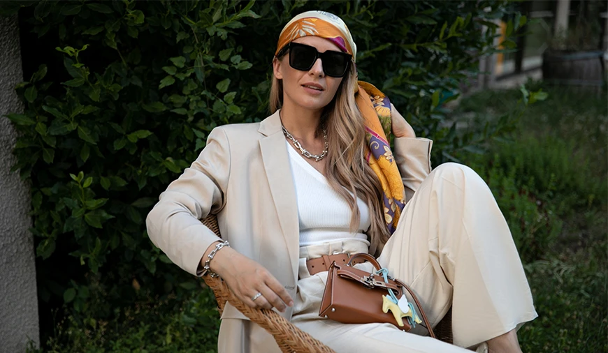 Жінка в стилі беж сидить на стільці на вулиці