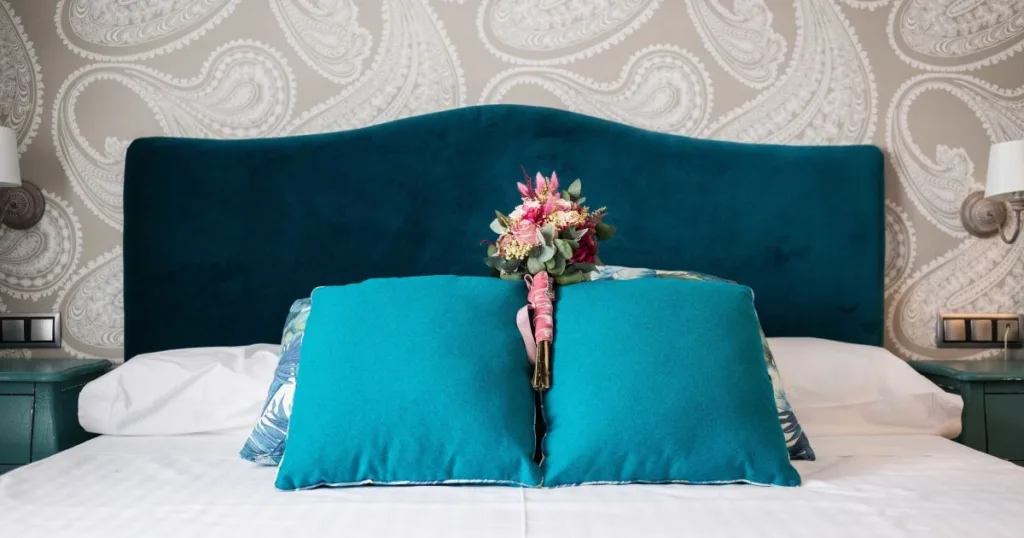 Букет квітів на ліжку з бірюзовими подушками