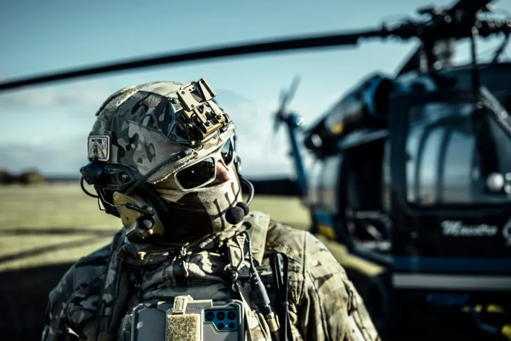 Солдат у камуфляжі біля військового гелікоптера