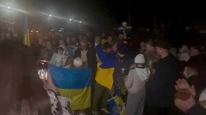 Натовп людей святкує з прапорами України вночі