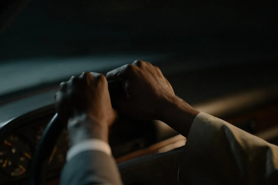Руки на кермі автомобіля вночі