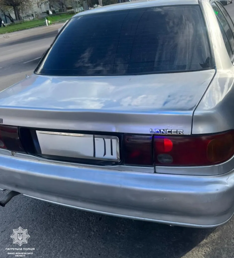 Срібний автомобіль Mitsubishi Lancer на вулиці