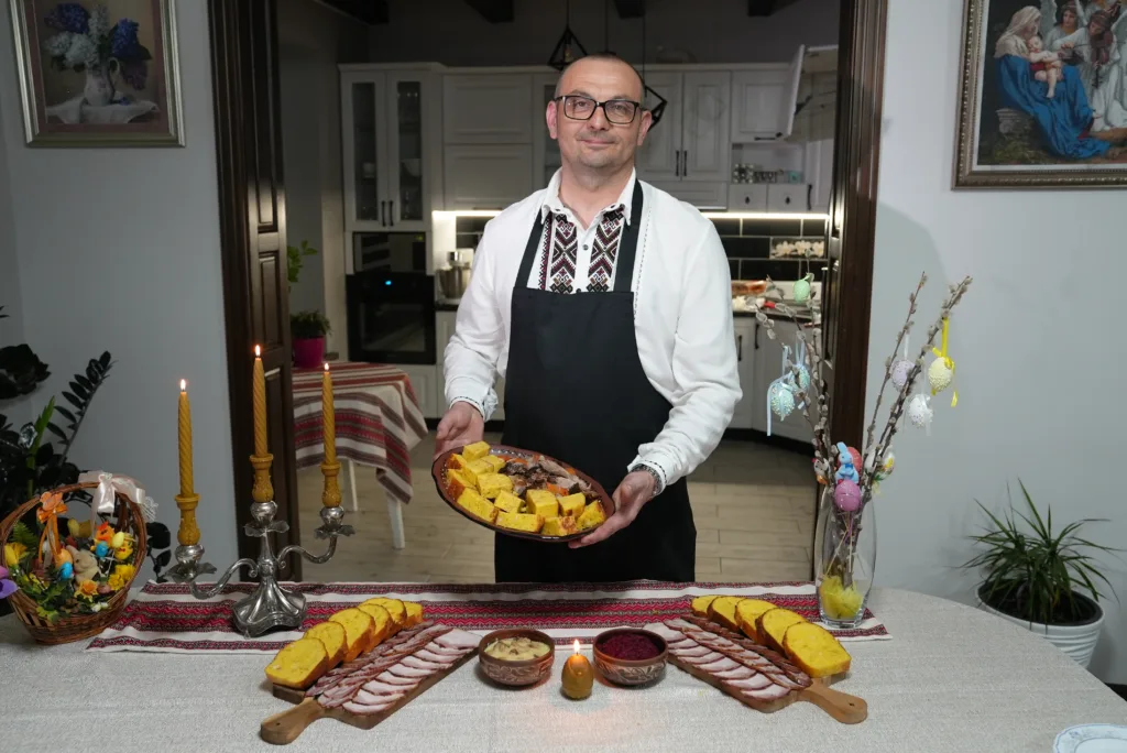Чоловік у вишиванці подає українські святкові страви