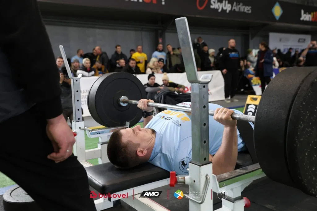 Спортсмен виконує жим штанги лежачи на змаганнях