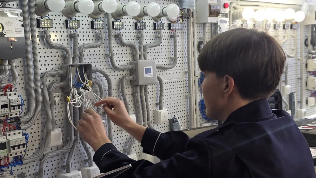 Електрик працює з проводами на щиті управління