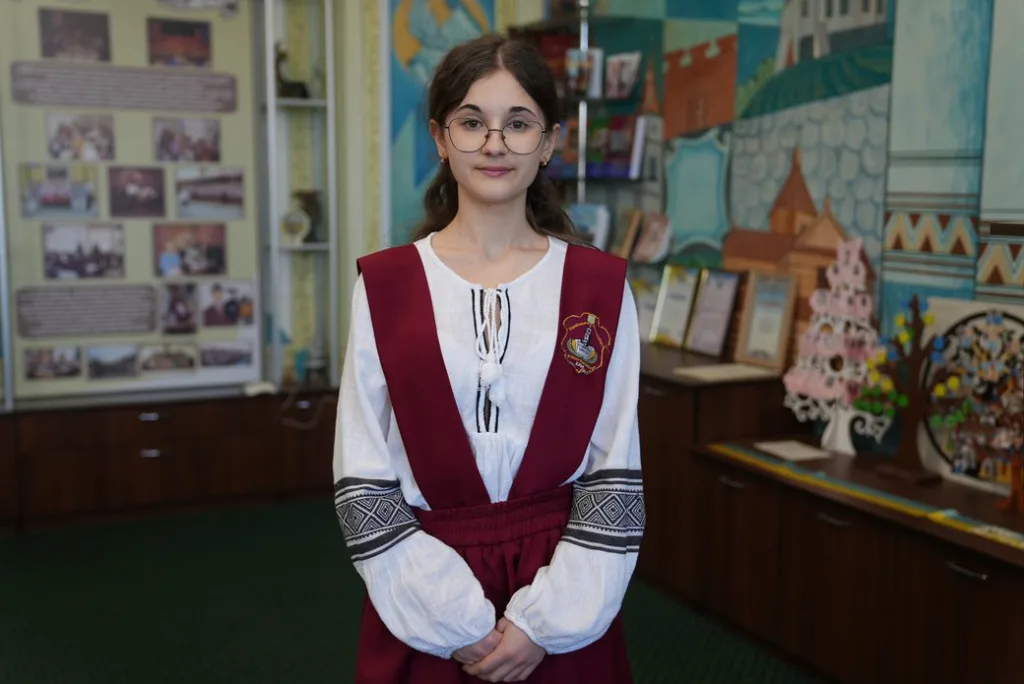Учениця у шкільній формі в музеї школи
