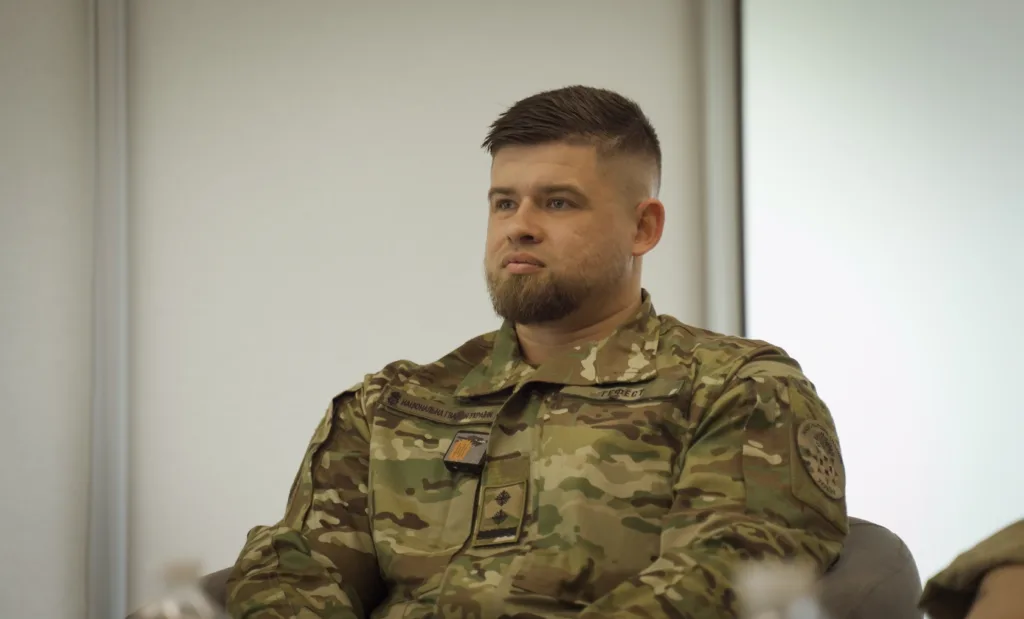 Військовий у камуфляжі сидить у приміщенні