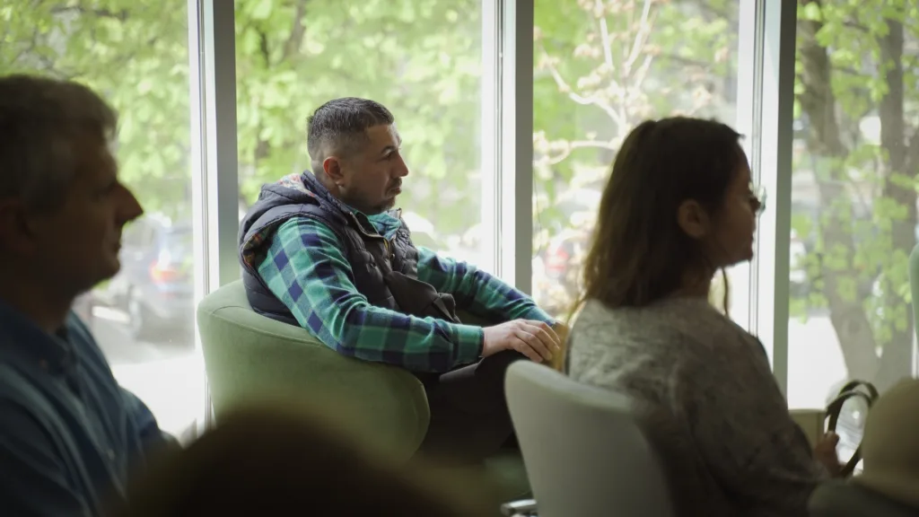 Люди слухають лекцію біля вікна