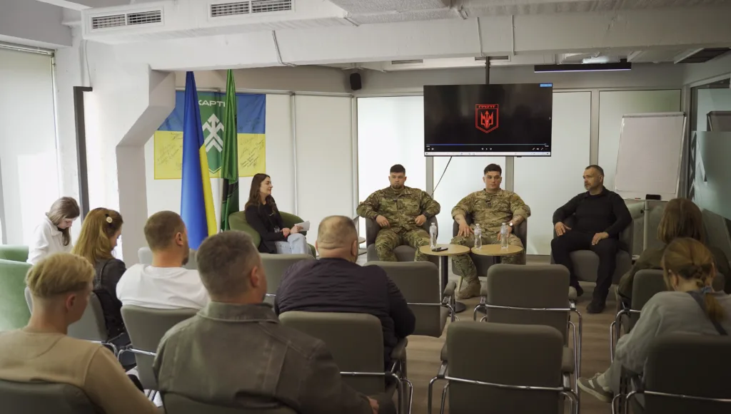 Військові виступають перед аудиторією у конференц-залі