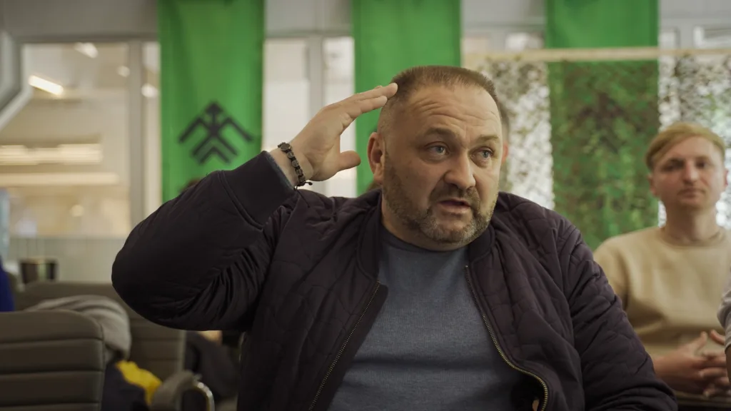 Чоловік жестикулює під час розмови в офісі