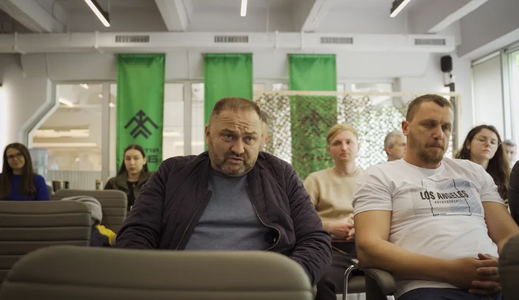 Люди слухають лекцію в навчальній аудиторії