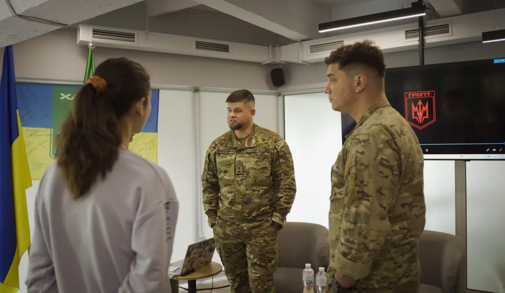 Військові спілкуються під українським прапором у приміщенні