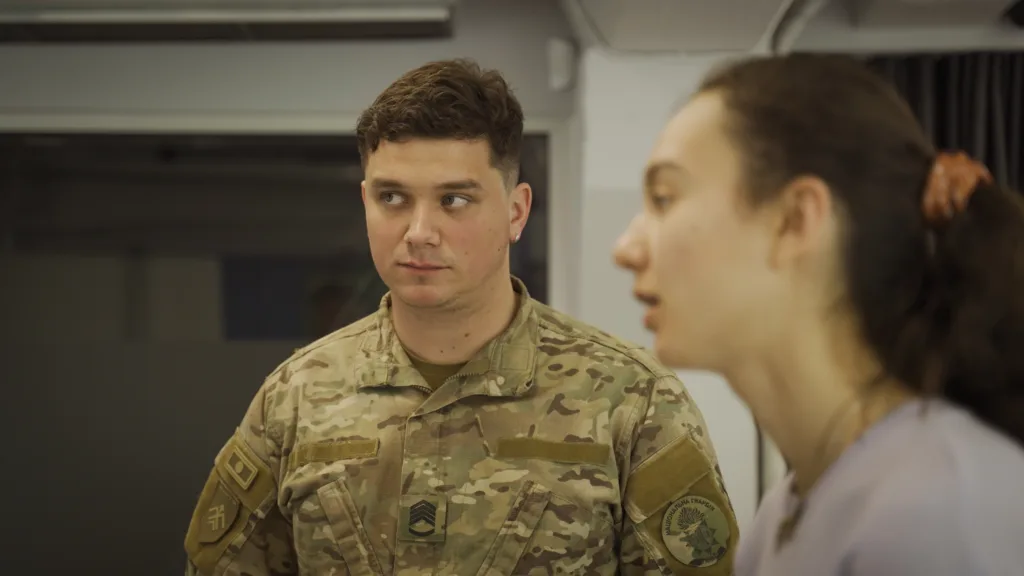 Військовий спілкується з жінкою у приміщенні