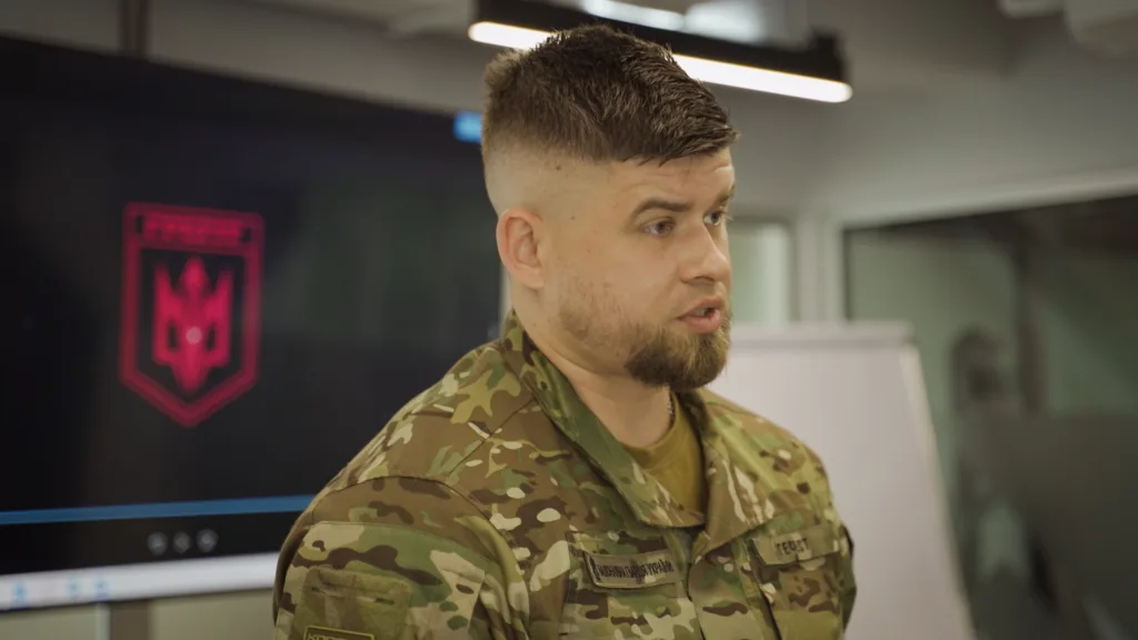 Військовий у камуфляжі говорить у приміщенні