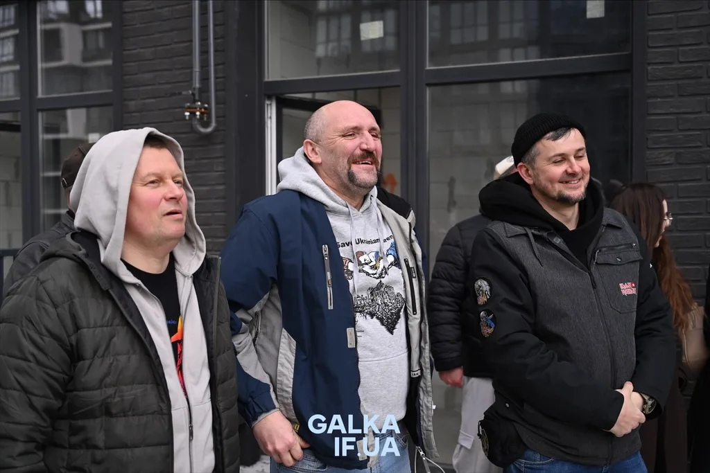 Троє чоловіків усміхаються на вулиці міста