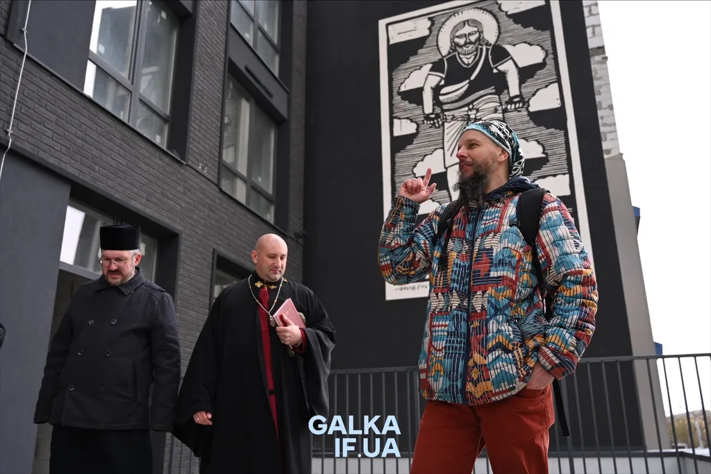 Люди біля муралу на стіні будівлі