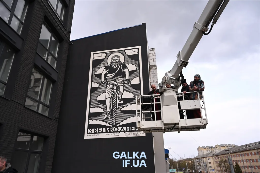 Художники малюють мурал на стіні будівлі