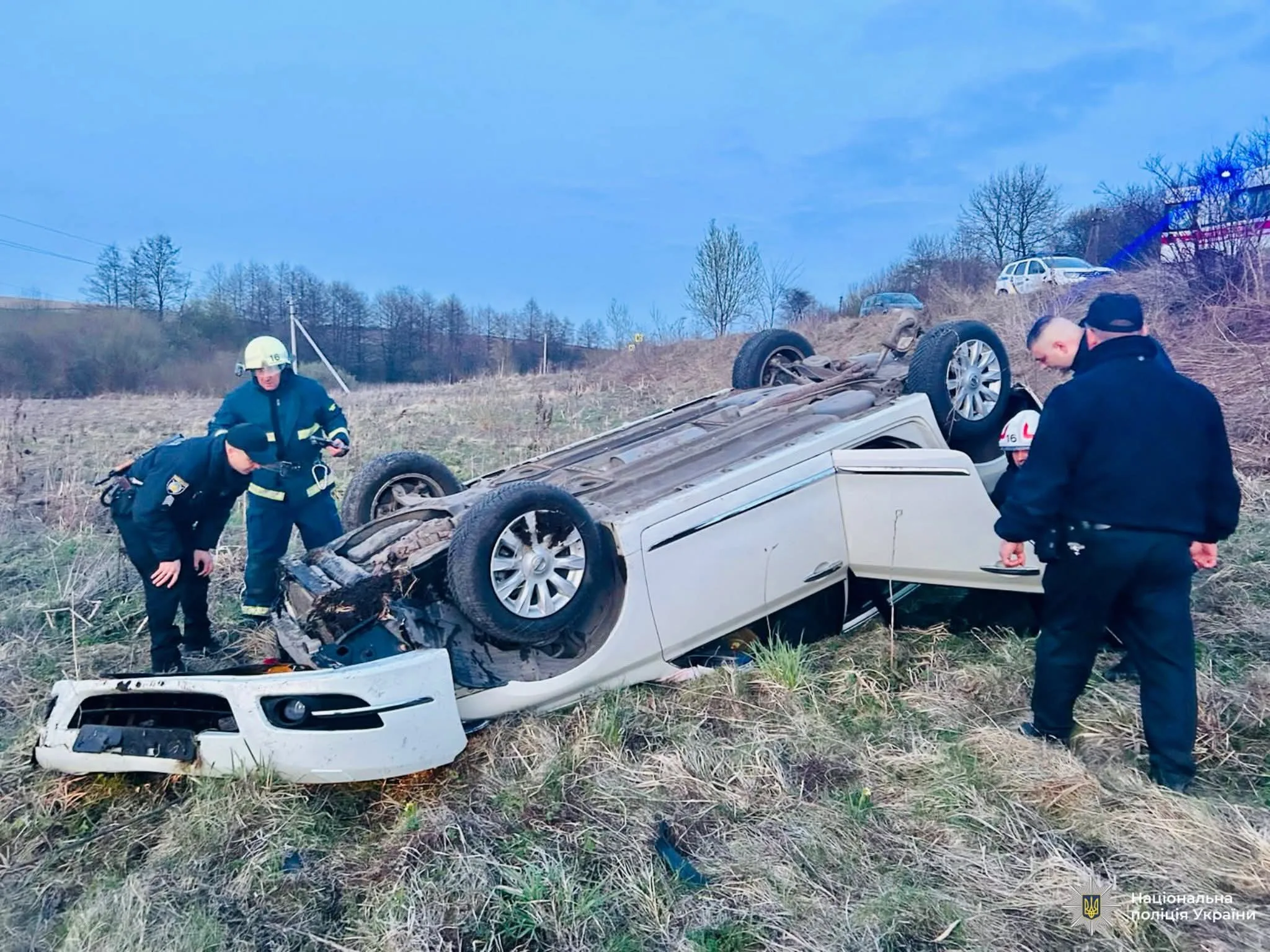 Рятувальники оглядають перекинутий автомобіль після аварії