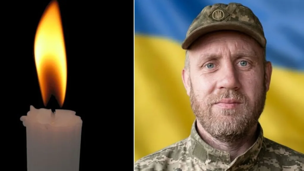 Свічка пам’яті та український військовий на фоні прапора