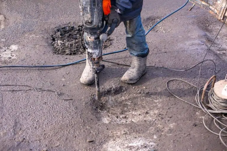 Робітник ремонтує асфальт відбійним молотком