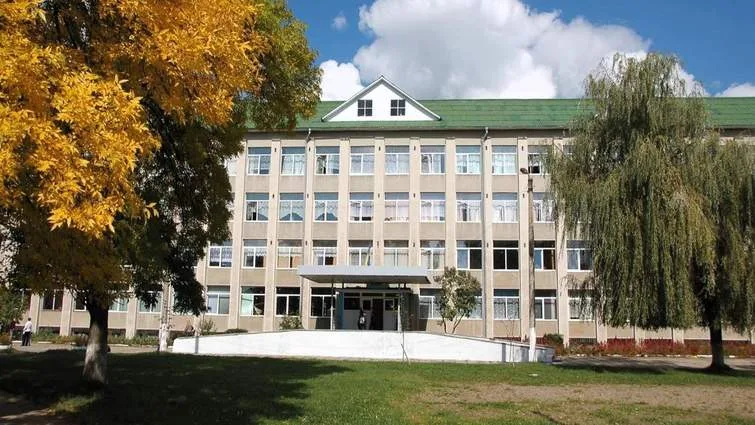 Фасад шкільної будівлі з деревами восени