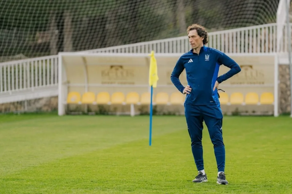 Тренер стоїть на футбольному полі під час тренування