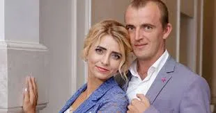 Пара усміхається поруч у святковому одязі