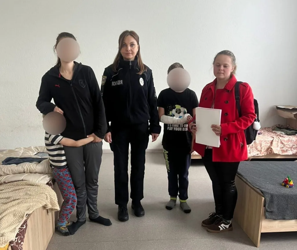 Поліцейська допомагає родині з дітьми у притулку