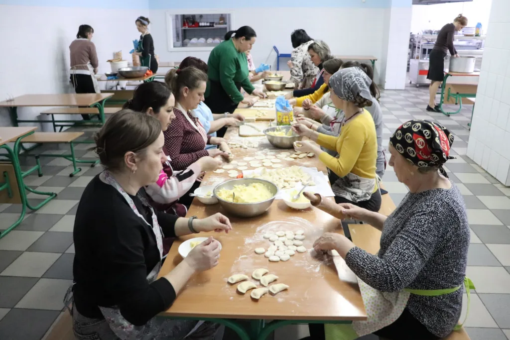 Жінки ліплять вареники на кухні разом