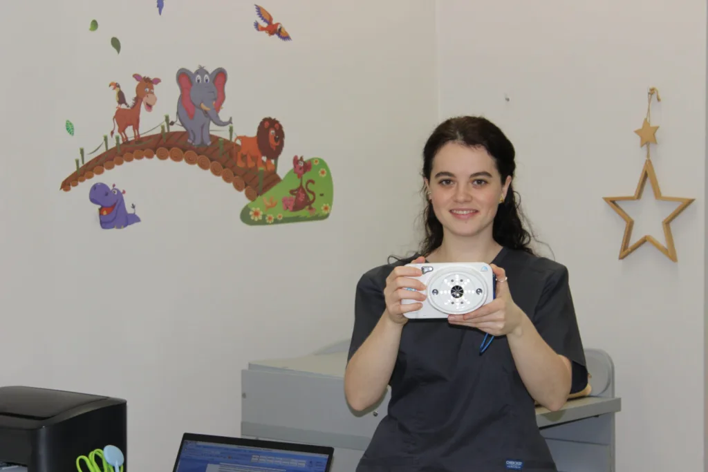 Жінка тримає медичний прилад у дитячому кабінеті