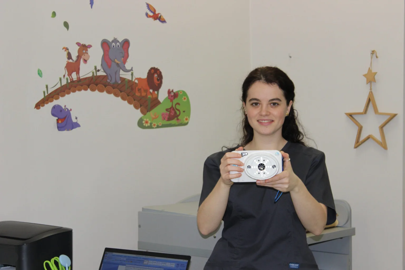 Жінка тримає медичний прилад у дитячому кабінеті