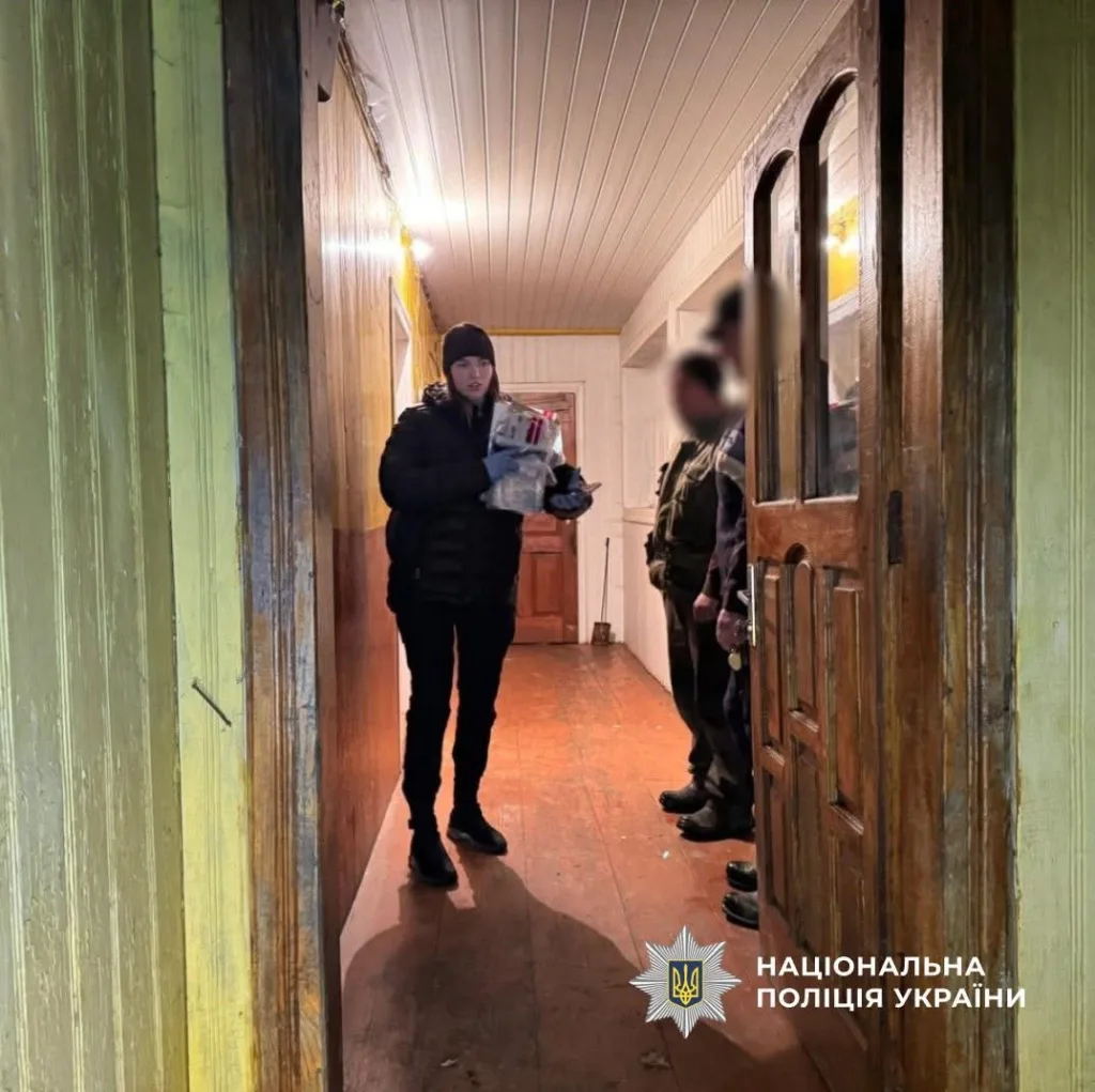 Поліцейські передають допомогу в дерев’яному будинку