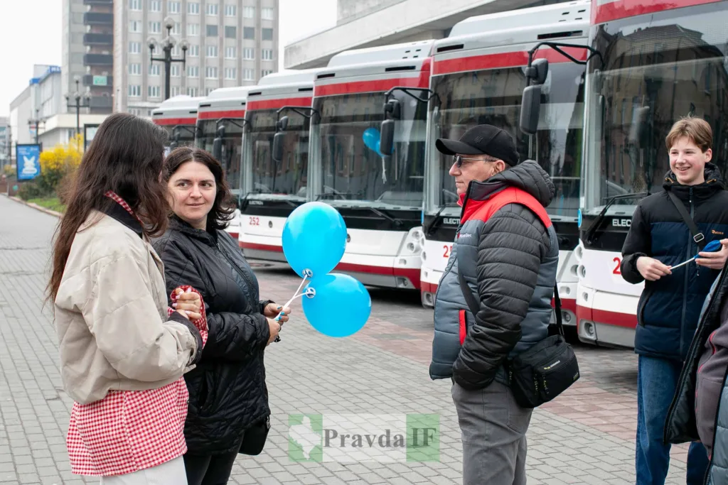 Люди спілкуються біля нових електробусів у місті