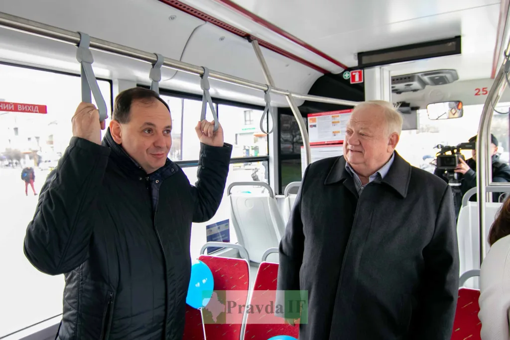 Двоє чоловіків розмовляють у міському автобусі