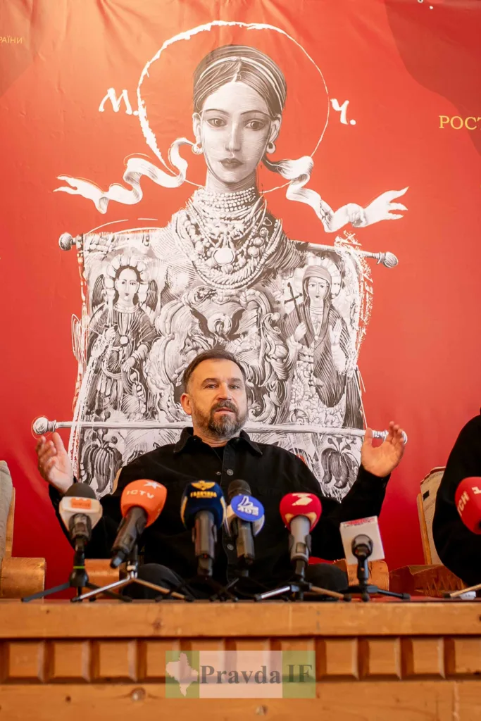 Пресконференція перед мистецьким постером на червоному тлі