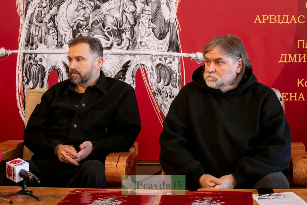 Двоє чоловіків на пресконференції перед червоним фоном