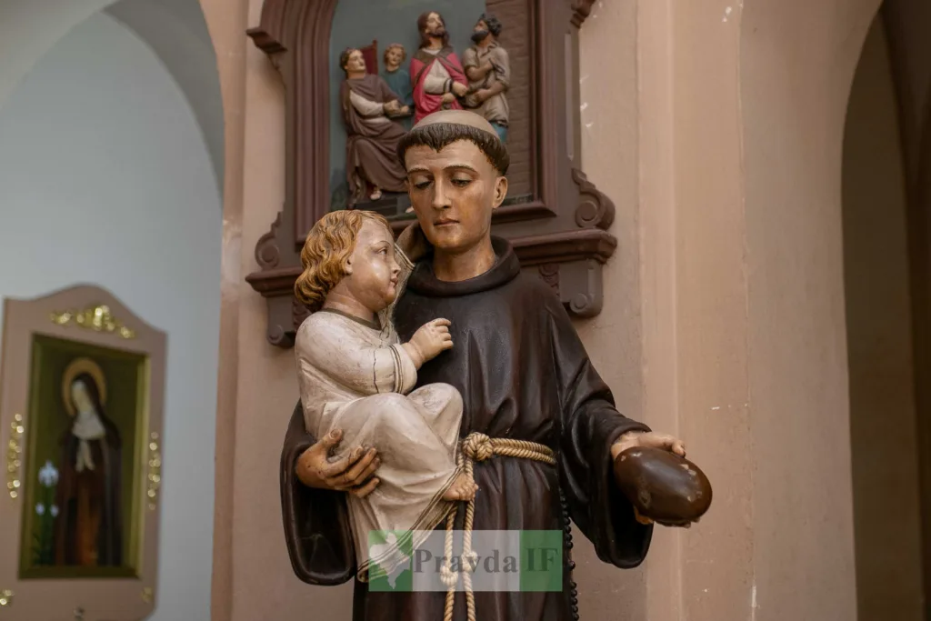 Дерев’яна скульптура монаха з дитиною в храмі