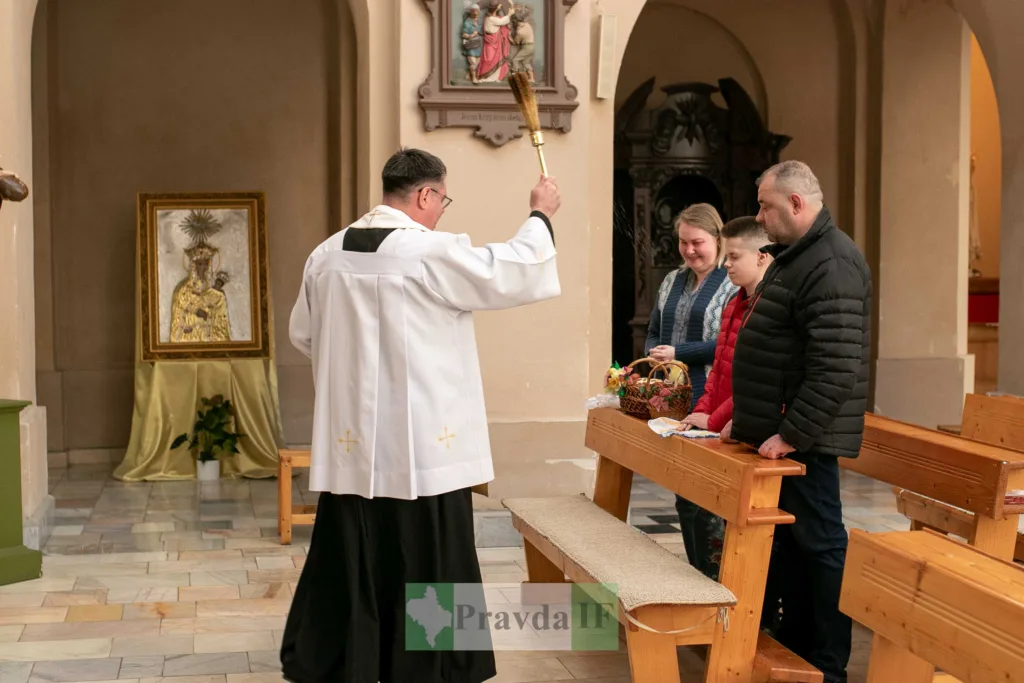 Священник освячує великодній кошик у церкві