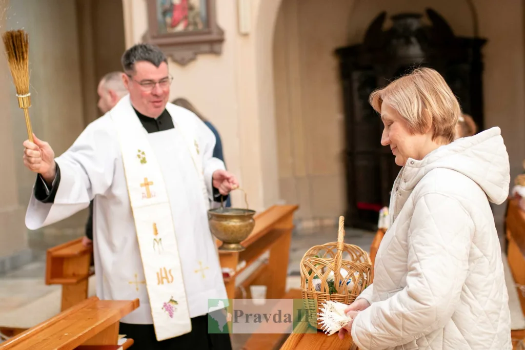 Священник освячує великодній кошик у церкві