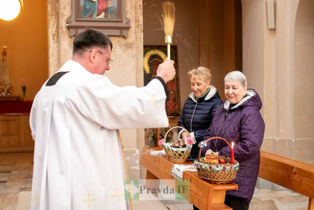 Священник освячує великодні кошики в церкві