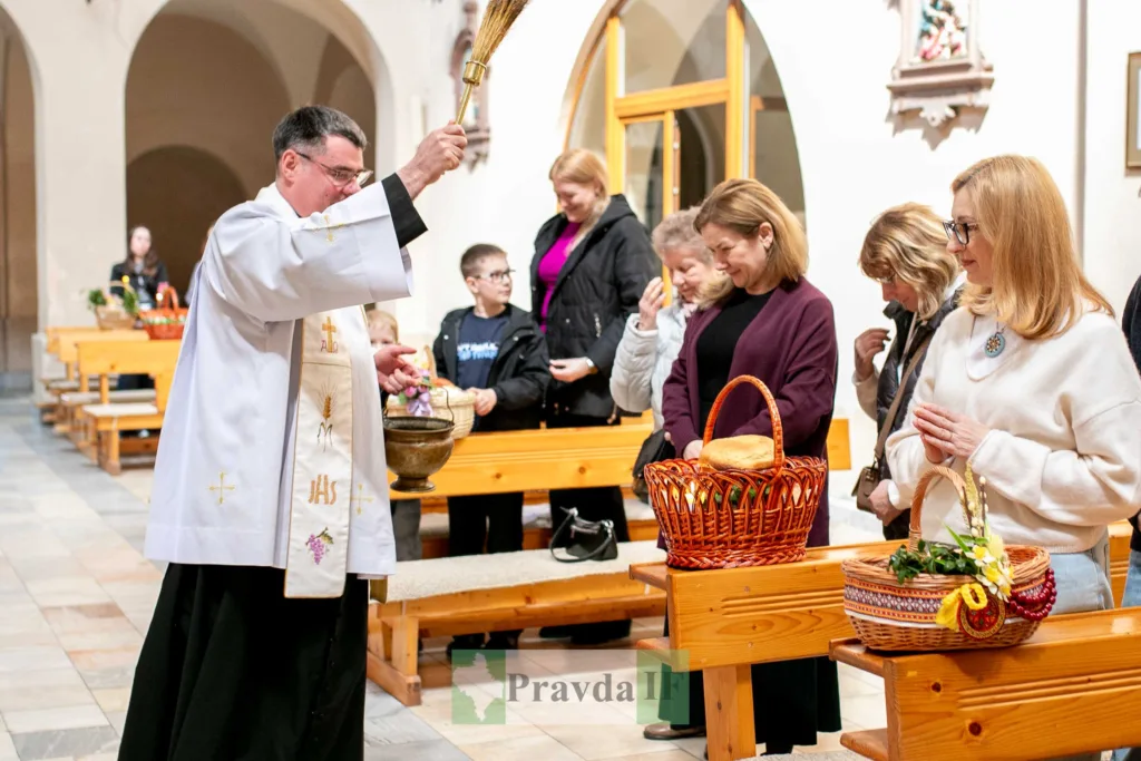 Священник благословляє великодні кошики у церкві