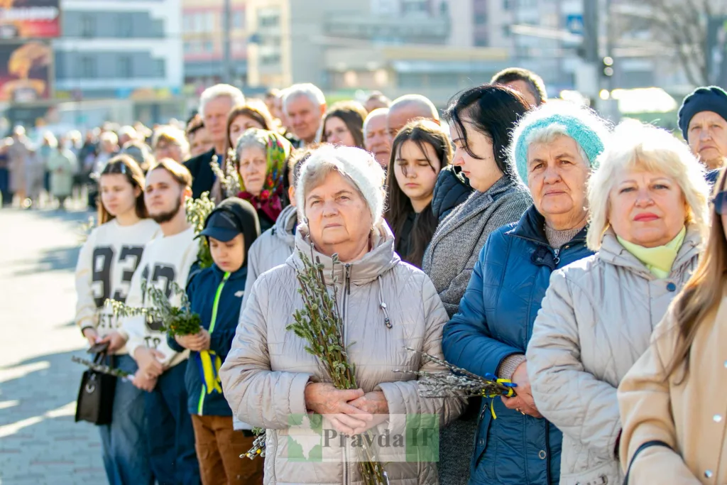Люди з вербовими гілками на вулиці міста