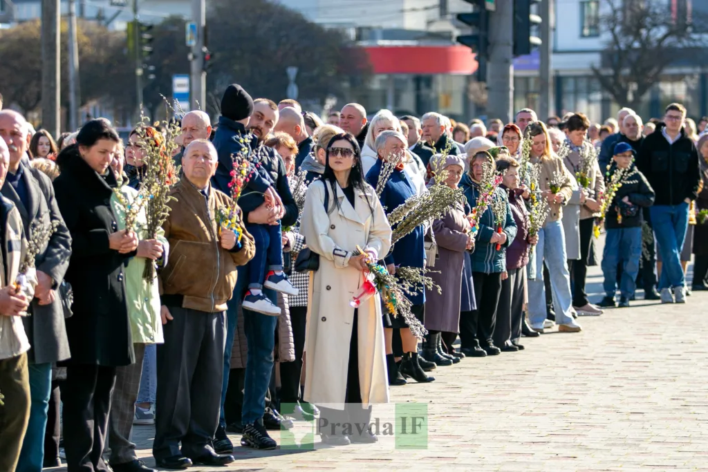 Люди з вербовими гілками на вулиці міста
